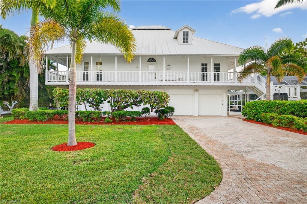 Image 3: View of front facade featuring a metal roof, decorative driveway, a front lawn, an attached garage, and a balcony