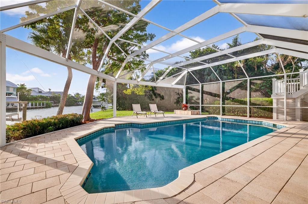 Image 4: Swimming pool with glass enclosure, a patio area, and a sunroom
