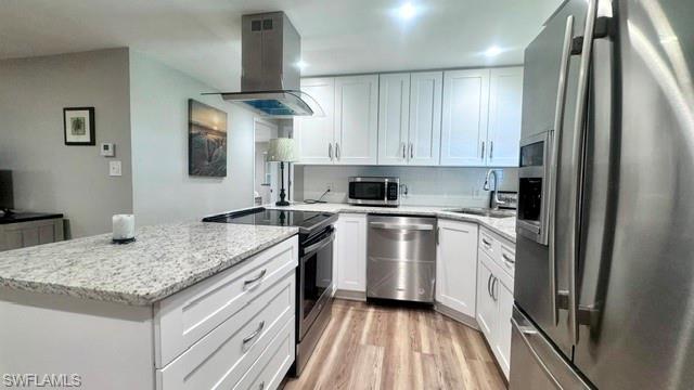Image 1: Modern kitchen featuring white shaker cabinetry, stainless steel appliances, speckled stone countertops, and wood-finish flooring