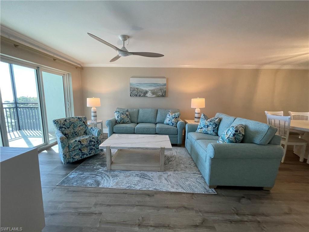 Image 4: Living area with ornamental molding, wood finished floors, and a ceiling fan