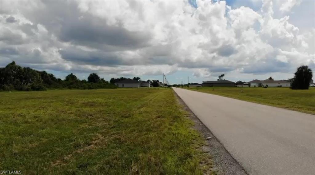 Image 1: View of asphalt street featuring a view of countryside