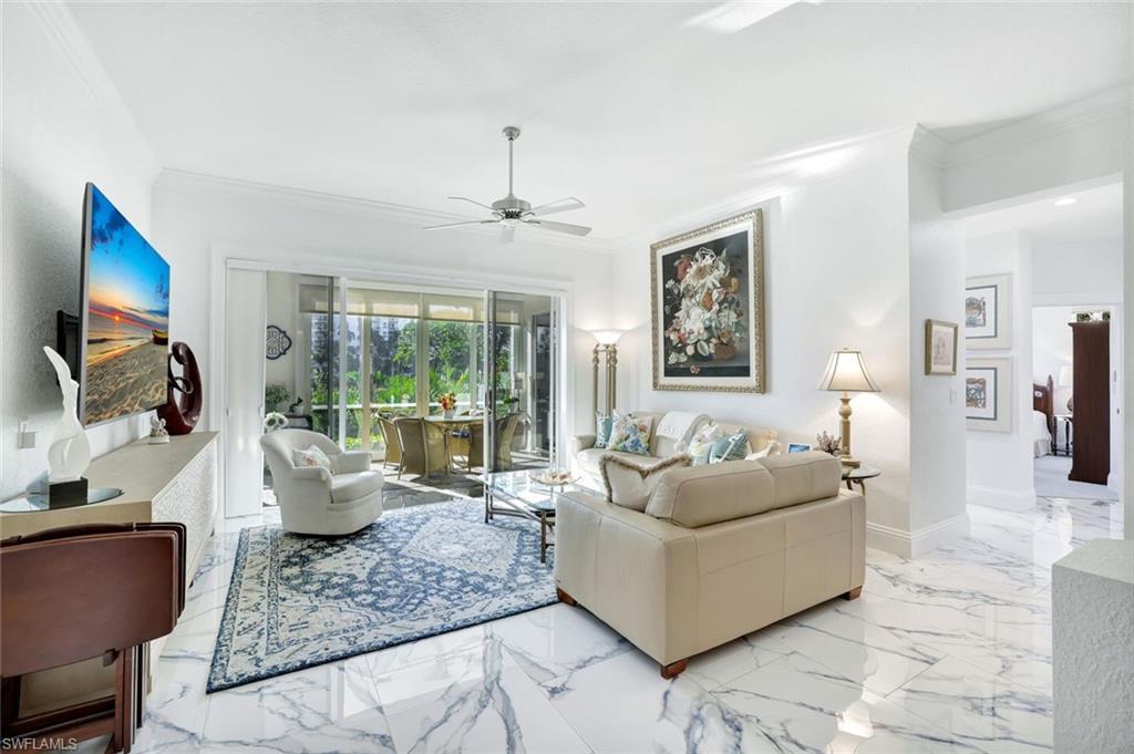 Image 1: Bright, open living area with polished tile floors and large sliders framing the tranquil outdoor scenery.