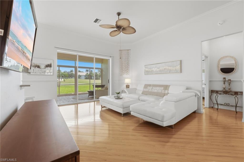 Image 3: Enjoy picturesque golf course views enhanced by dramatic soaring ceilings, beautiful luxury vinyl flooring, sun-filled living spaces, designer-appointed furnishings, and exquisite crown molding.