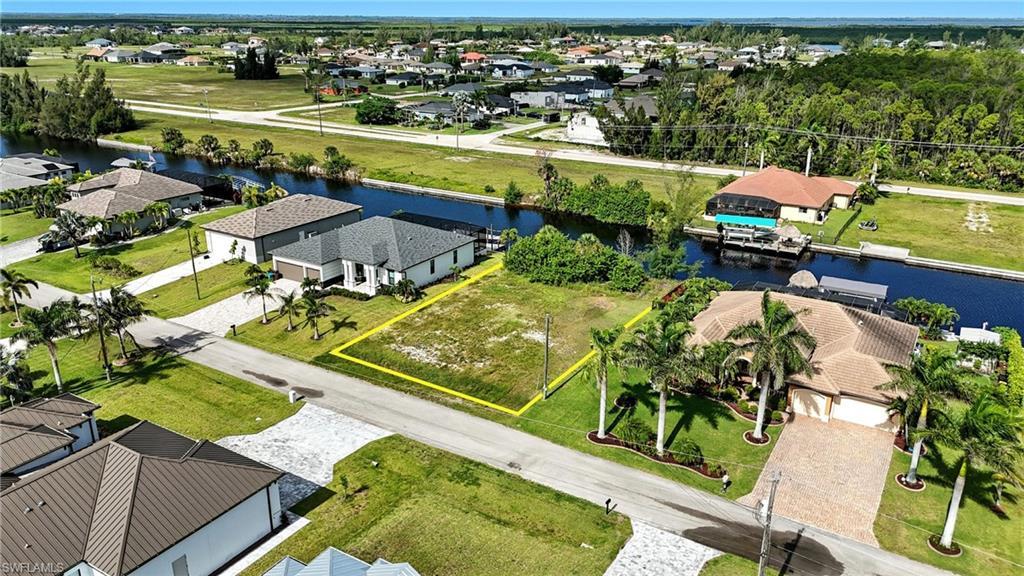 Image 1: Aerial view of residential area featuring a nearby body of water