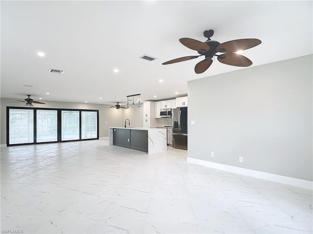 Image 4: Unfurnished living room with sink, ceiling fan, and light tile floors