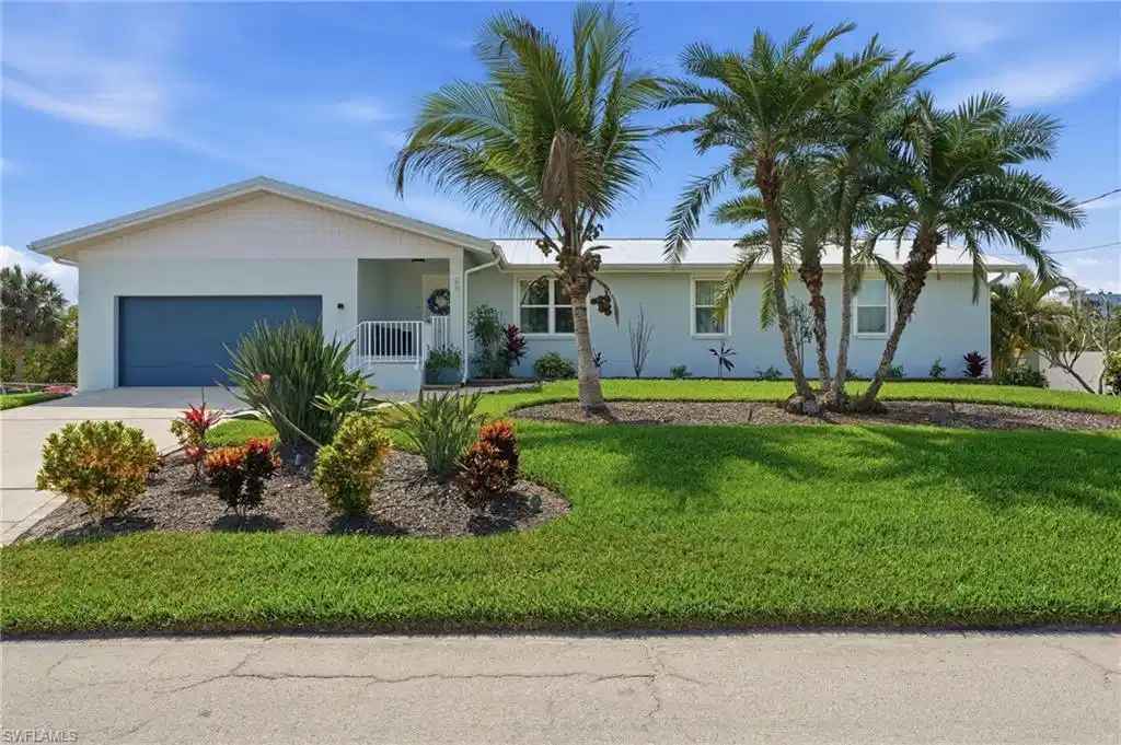 Image 1: Ranch-style home with a garage, driveway, stucco siding, and a front yard - Virtually Edited Image