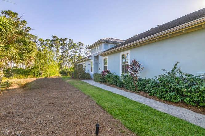 Image 3: Entry sidewalk, lots of green space, no neighbors on this side. Perfect for someone with a dog.