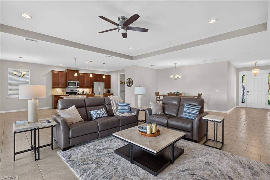 Image 4: Open-concept living space featuring neutral tile flooring, recessed lighting, and a ceiling fan