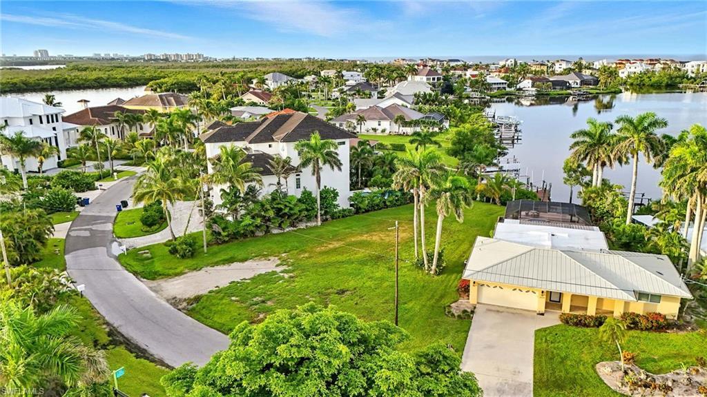 Image 1: Aerial view of residential area featuring a nearby body of water