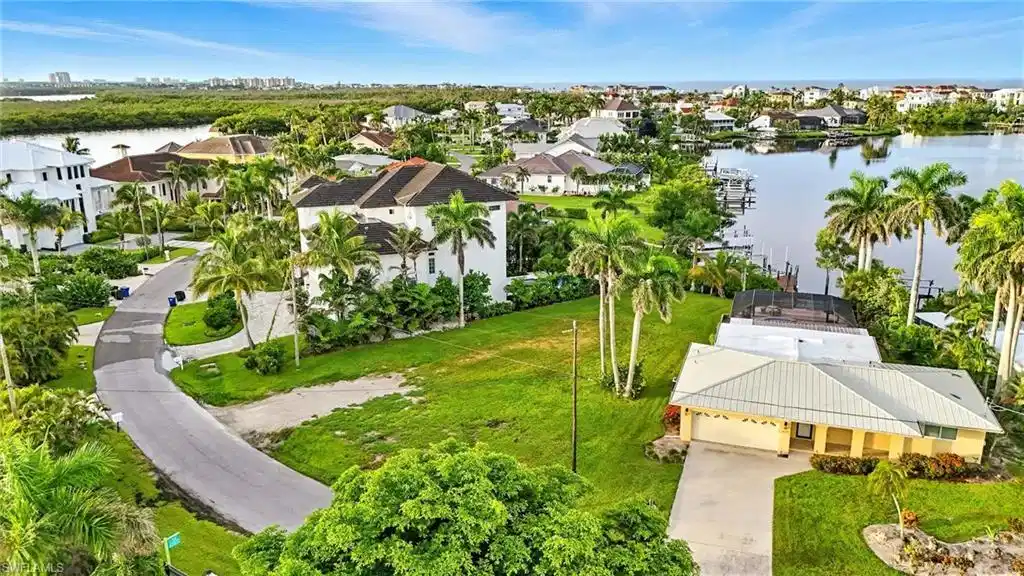Image 1: Aerial view of residential area featuring a nearby body of water