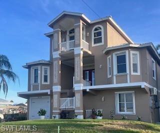 Image 1: View of front of house featuring a balcony, stucco siding, and a front yard