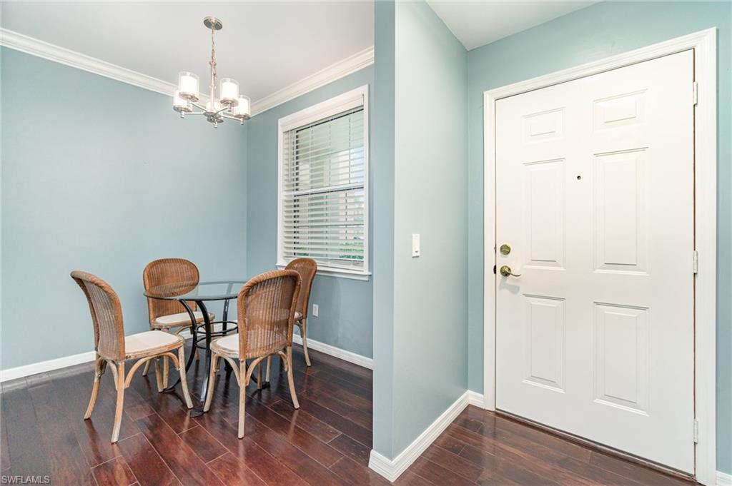 Image 4: Dining room/kitchen nook,dark wood-style floors, and crown molding