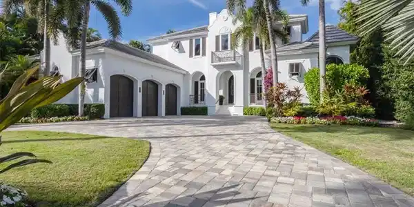 Image 4: Mediterranean / spanish-style home featuring decorative driveway, a front lawn, stucco siding, a balcony, and a garage