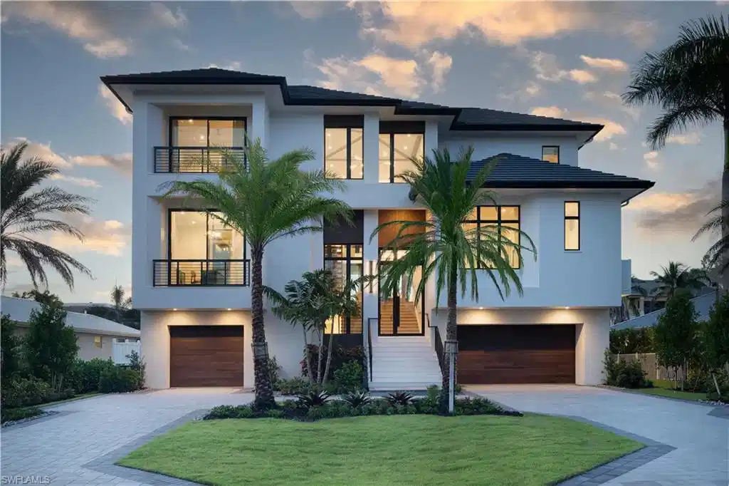 Image 1: Modern multi-story residence featuring a white stucco exterior and black framed windows