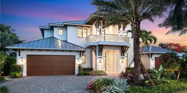 Image 2: View of front of property featuring a standing seam roof, a balcony, an attached garage, metal roof, and decorative driveway