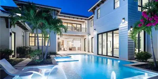 Image 4: Back of property featuring a pool with connected hot tub and a balcony