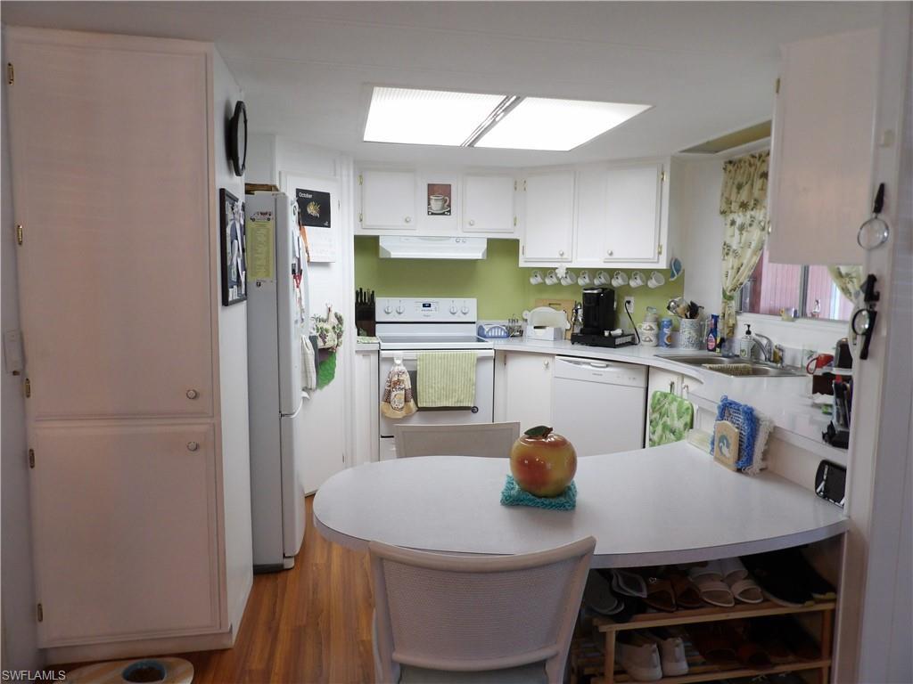 Image 4: Kitchen with white appliances, a peninsula, white cabinets, and light countertops
