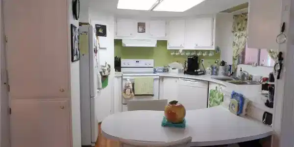 Image 4: Kitchen with white appliances, a peninsula, white cabinets, and light countertops