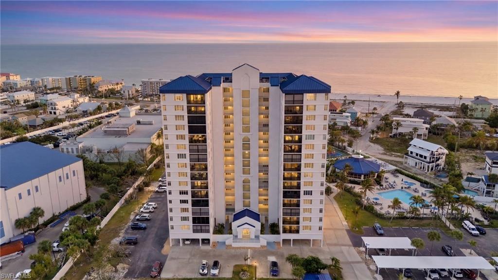 Image 2: Property at dusk with a water view and a view of apartment building / complex - Virtually Edited Image