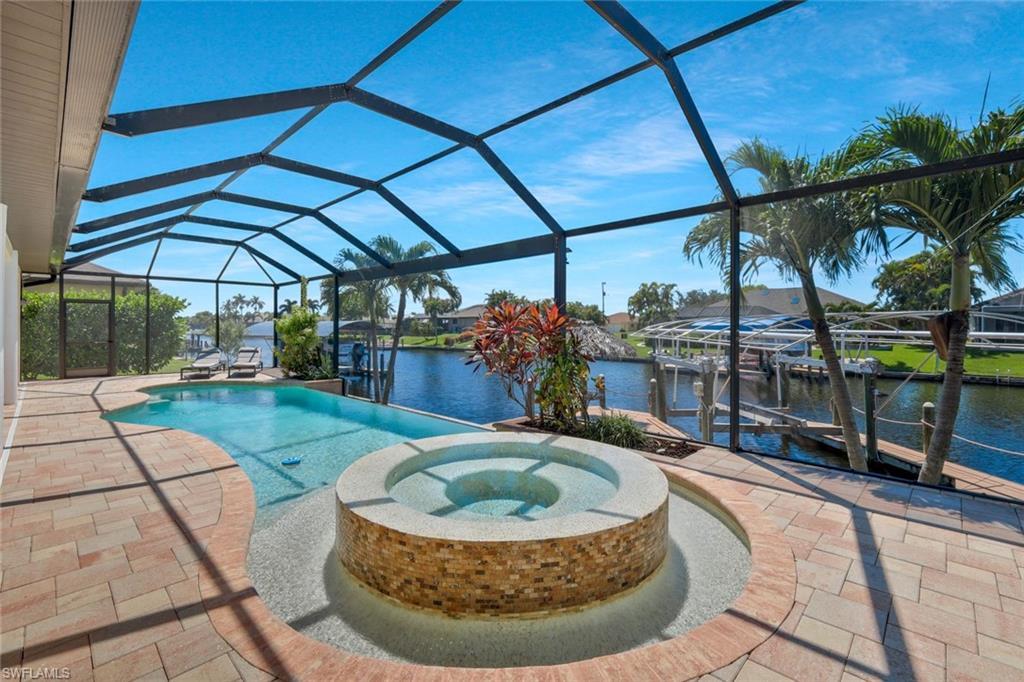 Image 1: View of swimming pool featuring a sunroom, a water view, a patio area, and a dock