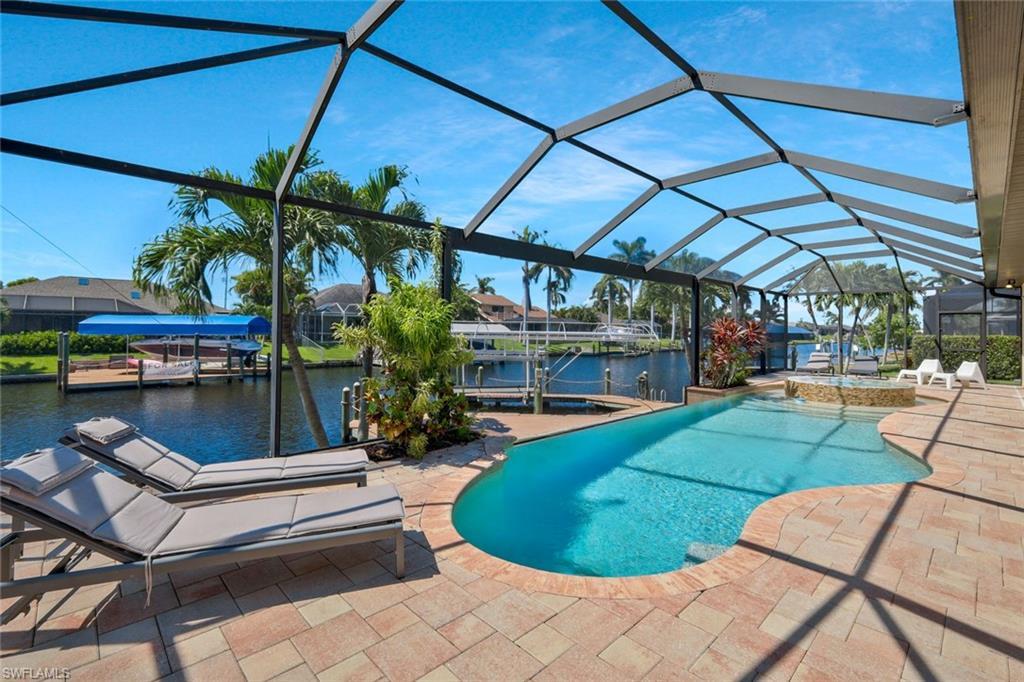 Image 3: Swimming pool featuring a patio area, a sunroom, boat lift, a water view, and a boat dock