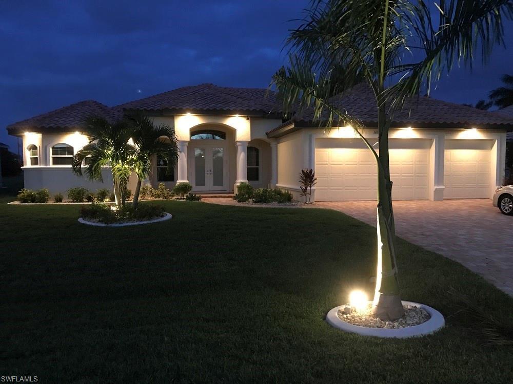 Image 4: View of front facade featuring french doors, decorative driveway, a yard, stucco siding, and a garage