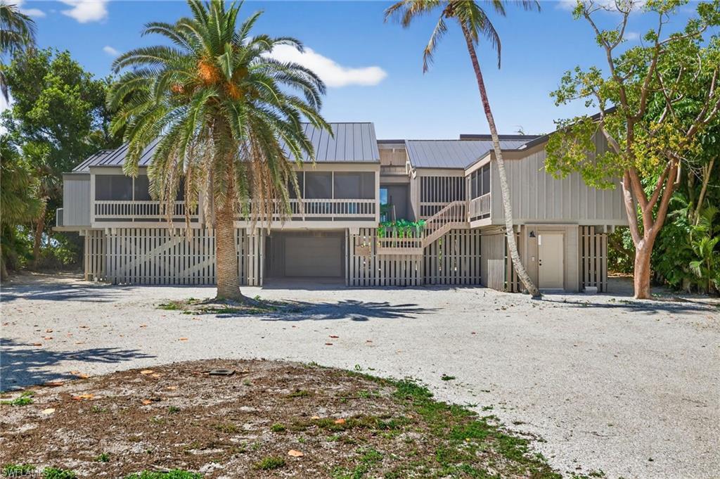 Image 4: View of front of house featuring a metal roof, driveway, a garage, and a balcony