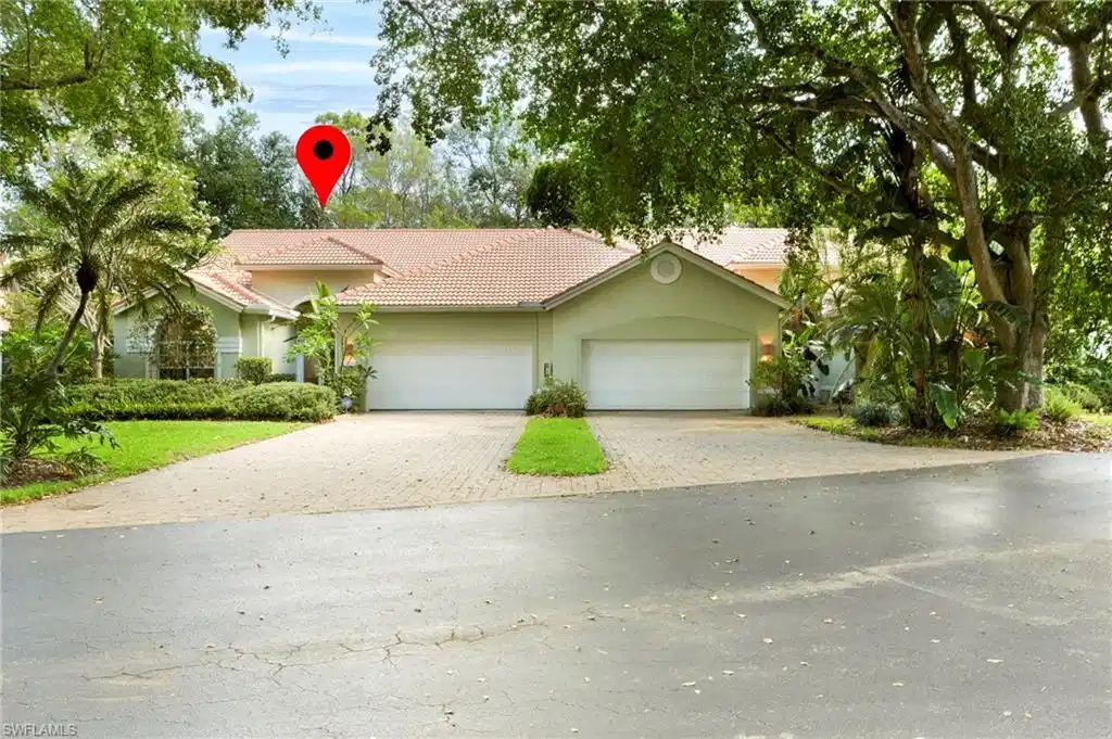 Image 1: View of front of property with a tile roof, paver driveway, and attached double garage