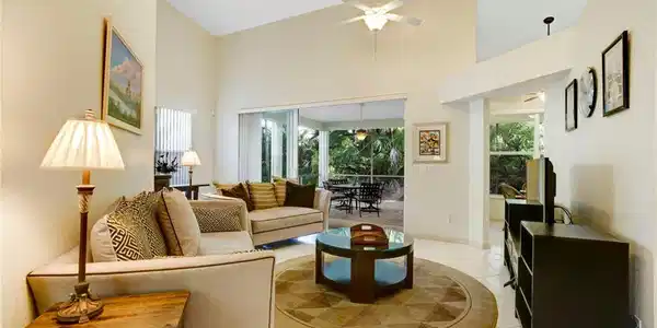 Image 3: Living area featuring high vaulted ceiling, tile floors, and triple sliders that are impact glass