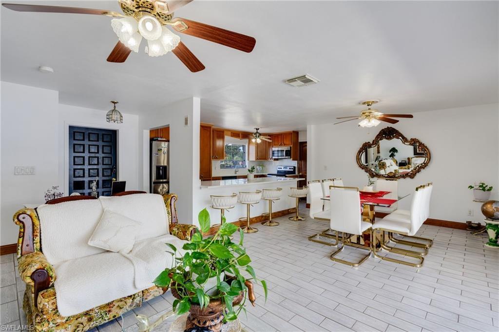 Image 3: Open-concept living space with light-toned tile flooring throughout