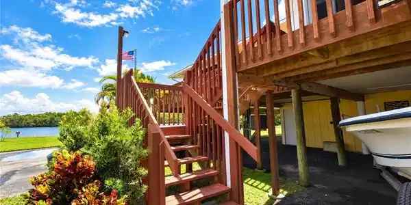 Image 3: Wood-finish exterior stairs and elevated deck with balusters