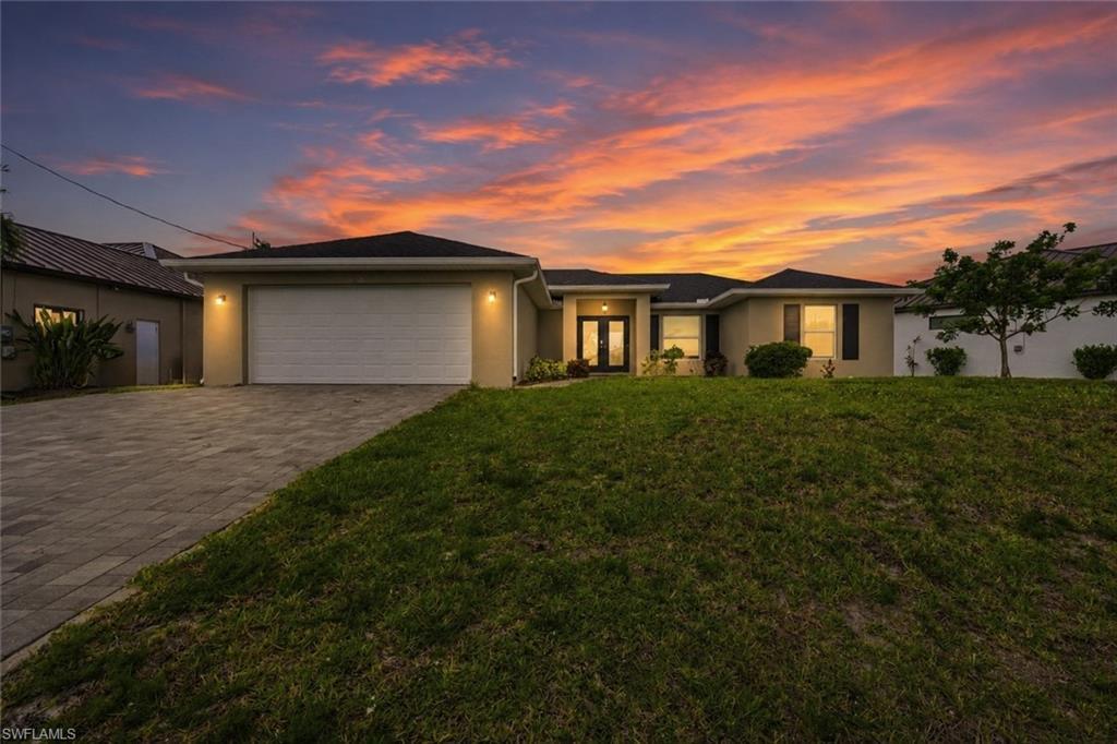 Image 1: Exterior residence with an attached garage and a paver driveway