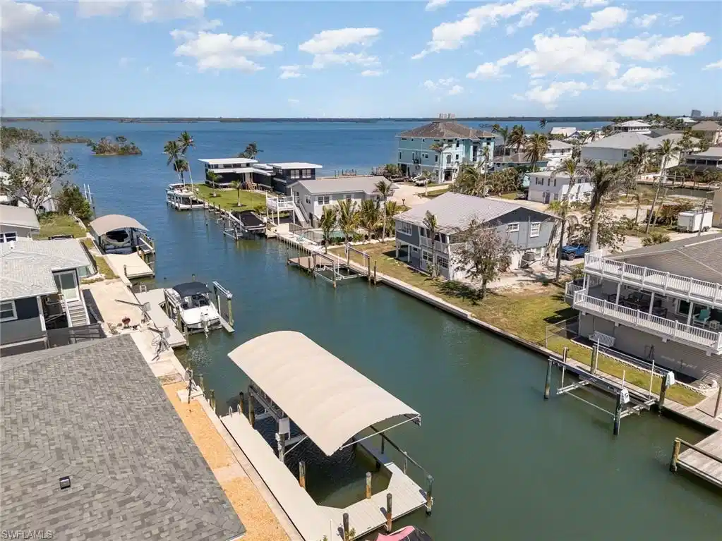 Image 1: Aerial view of residential area featuring a nearby body of water