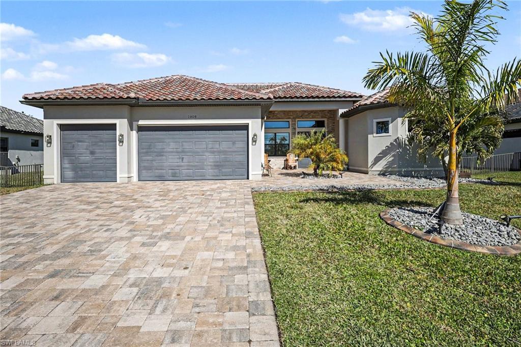 Image 2: Mediterranean / spanish-style house with a tiled roof, stucco siding, a garage, and driveway