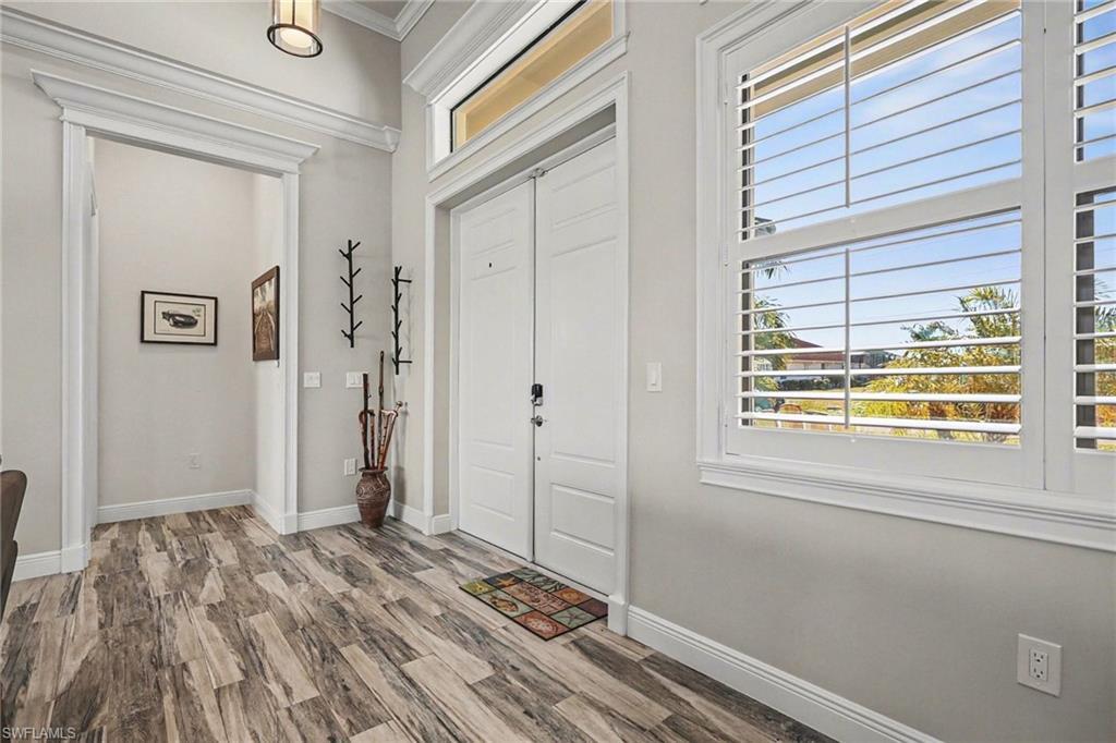 Image 3: Entryway with wood finished floors and crown molding