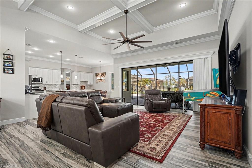Image 4: Living area featuring crown molding, recessed lighting, coffered ceiling, ceiling fan, and light wood finished floors