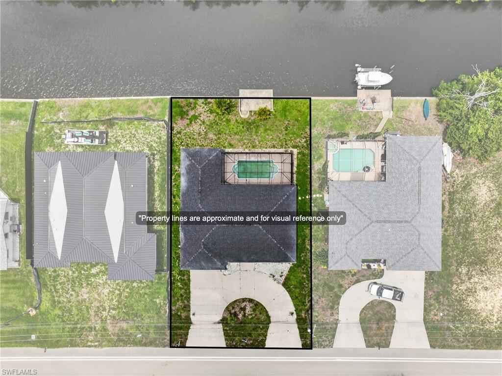 Image 2: Waterfront property featuring a private boat dock, in-ground swimming pool, and a circular driveway