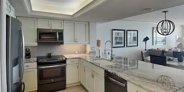 Image 4: Modern kitchen featuring light-toned cabinetry, a stainless-steel refrigerator, and a built-in microwave
