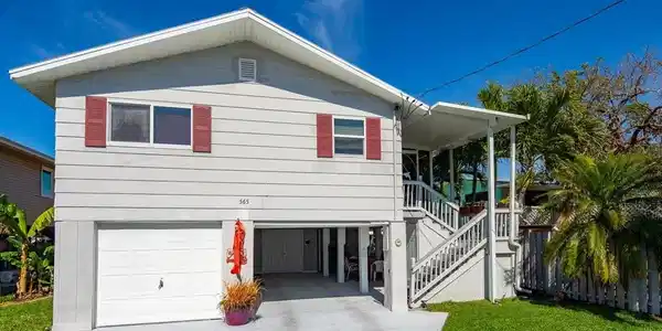 Image 2: View of front of property with a carport, a garage, and a front lawn