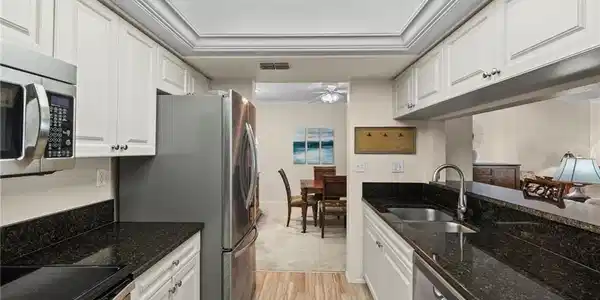 Image 3: Kitchen with white cabinets, ceiling fan, appliances with stainless steel finishes, and sink