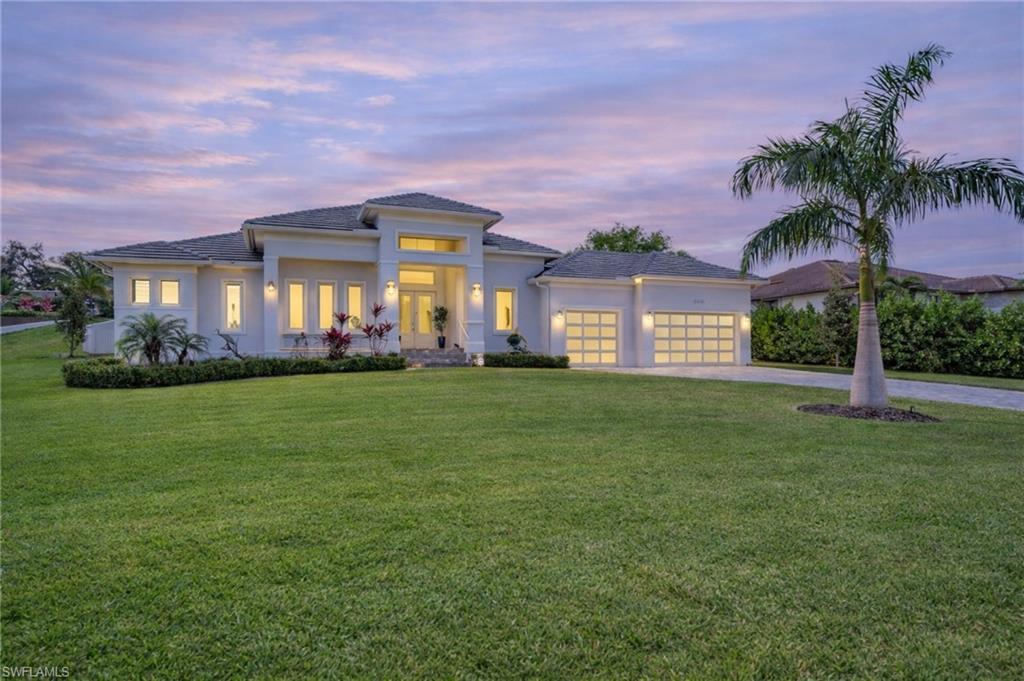 Image 3: Prairie-style home featuring driveway, a front lawn, stucco siding, and a garage