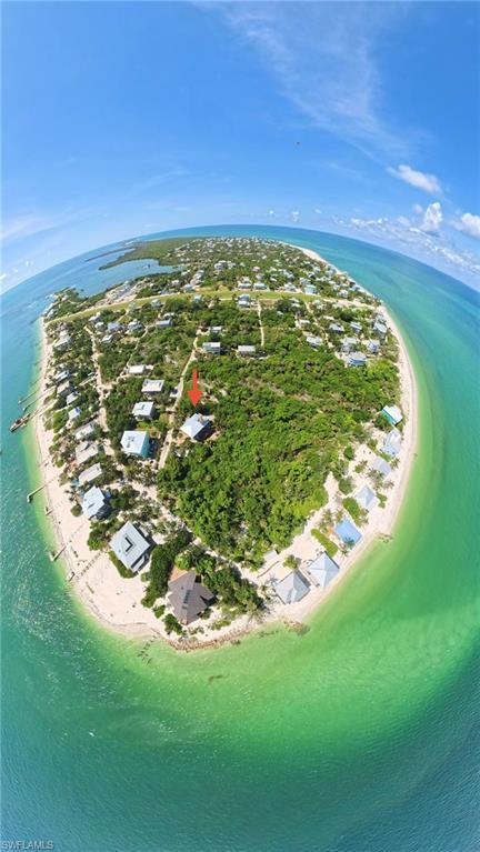 Image 2: Coastal land parcel on a barrier island, featuring surrounding clear blue-green waters, white sand beaches, and lush natural vegetation