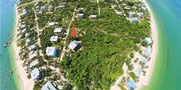 Image 2: Coastal land parcel on a barrier island, featuring surrounding clear blue-green waters, white sand beaches, and lush natural vegetation