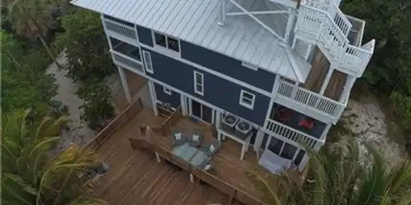 Image 3: Elevated coastal residence featuring a metal roof and multiple levels of outdoor decking