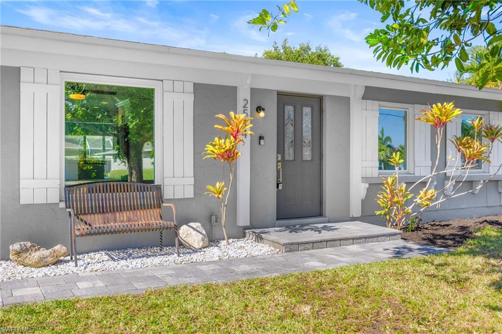 Image 3: View of exterior entry with a yard and stucco siding