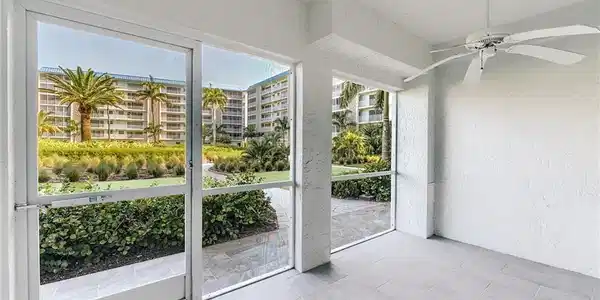 Image 4: Screened lanai featuring large format tile flooring, a ceiling fan, and a tropical landscape backdrop
