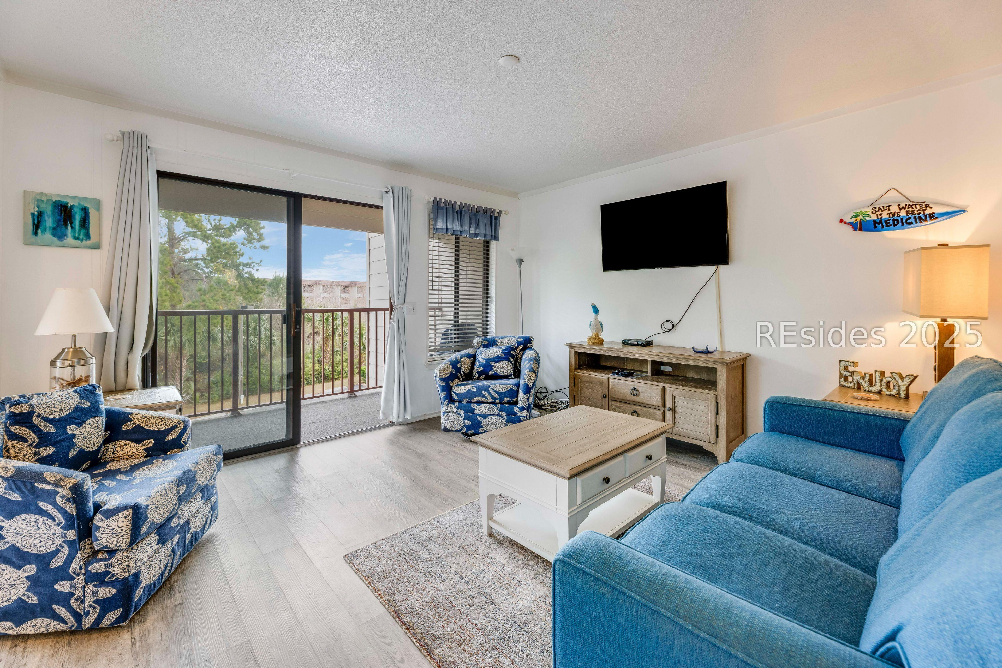 Image 2: Living room with new furniture opens to deck.