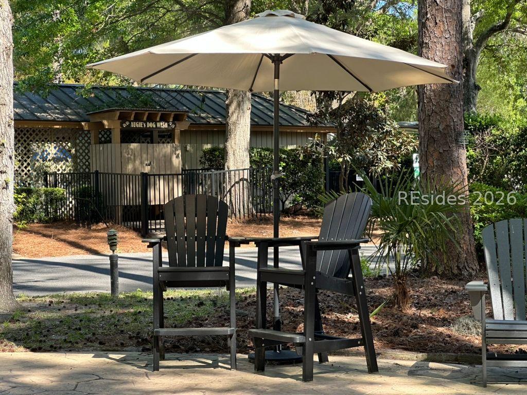 Image 3: Sit under an umbrella across from Dog Wash & pool