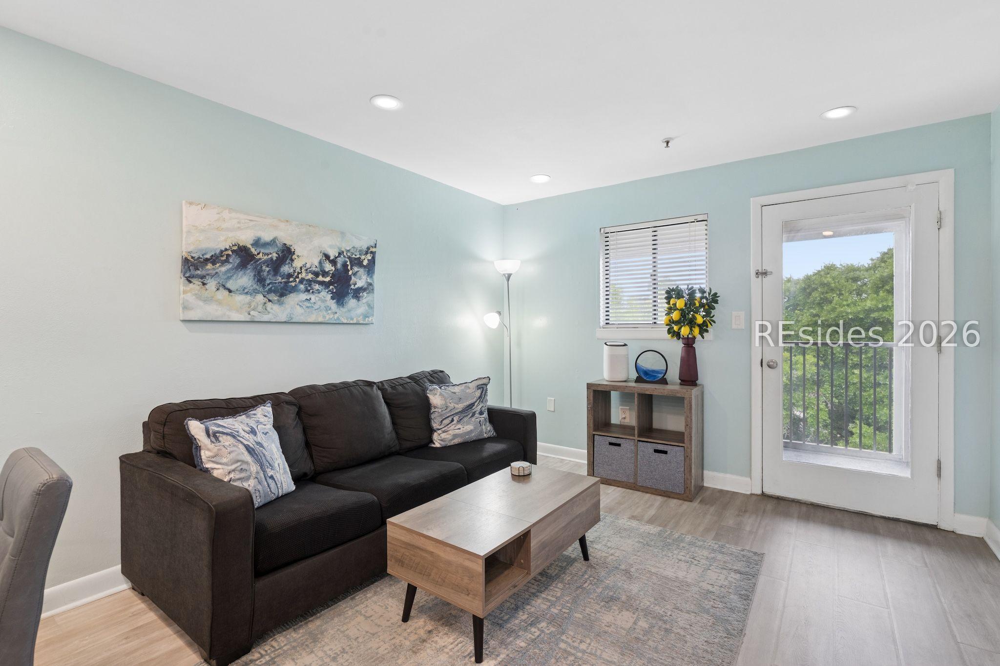 Image 2: Living Room leading to private screened-in balcony