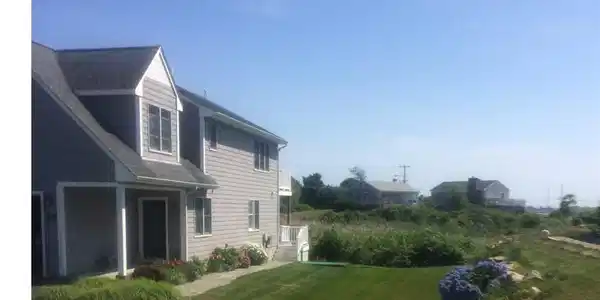 Image 2: Side view of home and its entry that showcases the